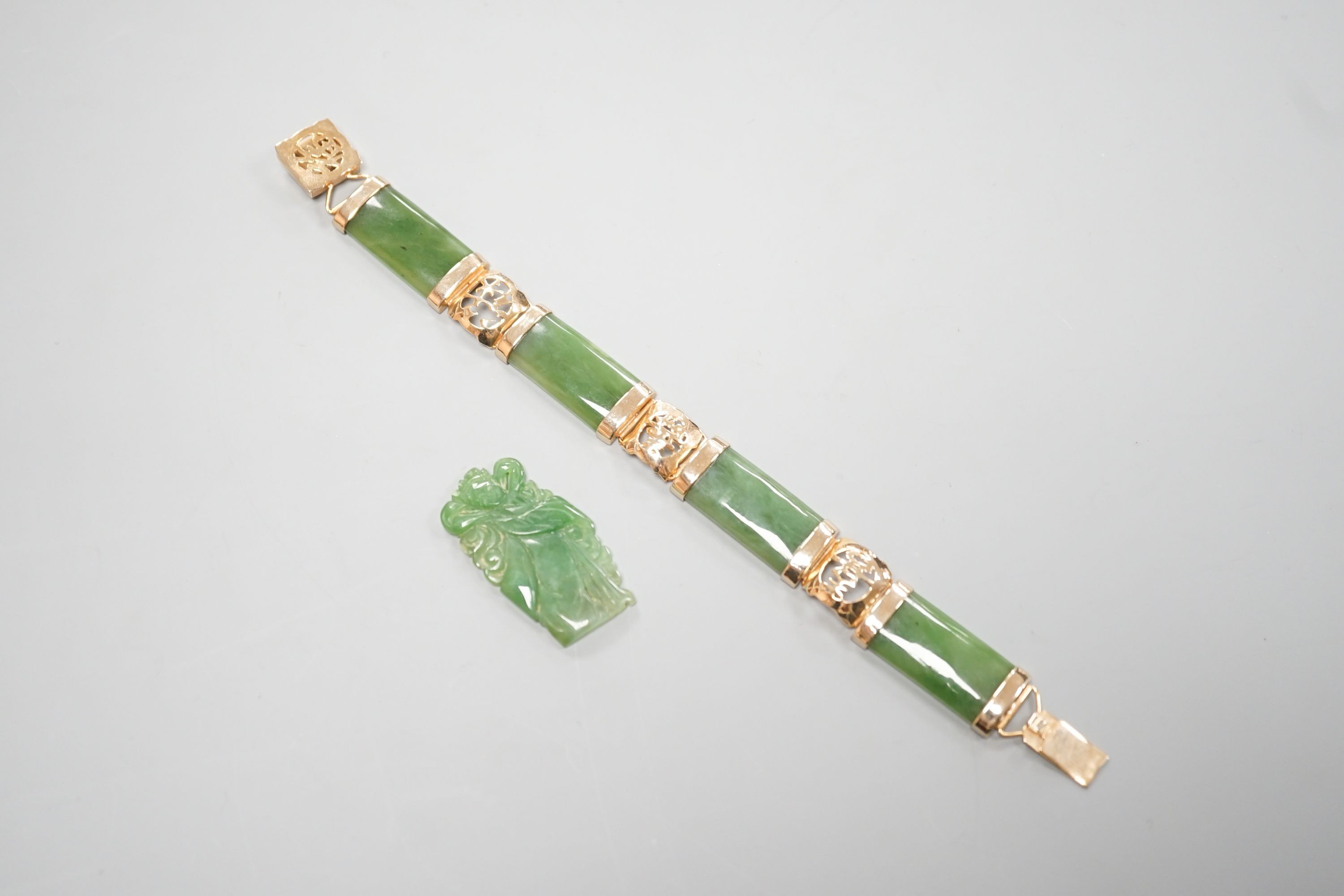 A gilt metal and jadeite mounted bracelet, 17.4cm and a carved plaque.